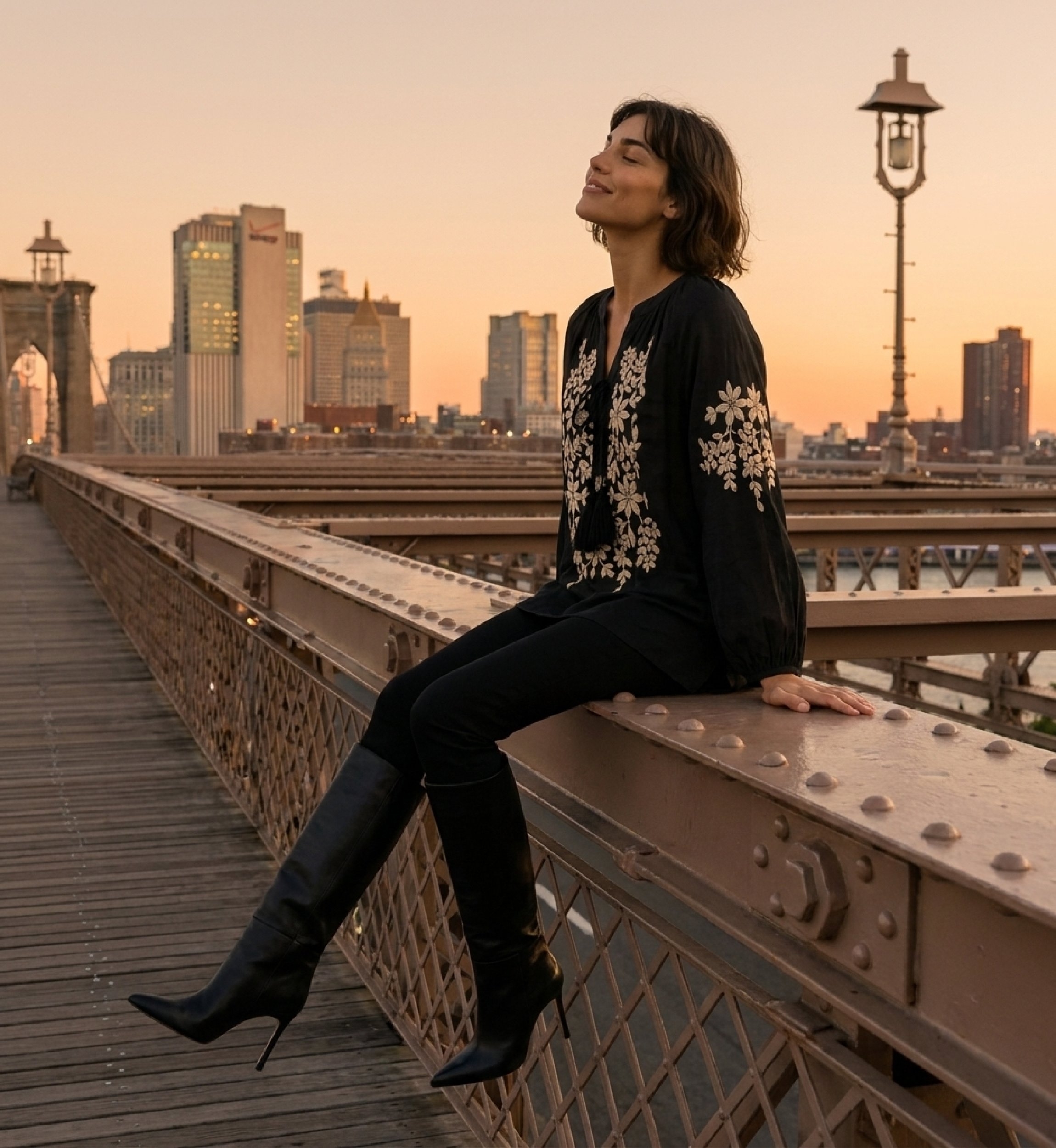 Black long-sleeve peasant blouse, v-neck tie, cream floral embroidery, linen-look, model seated at sunset.