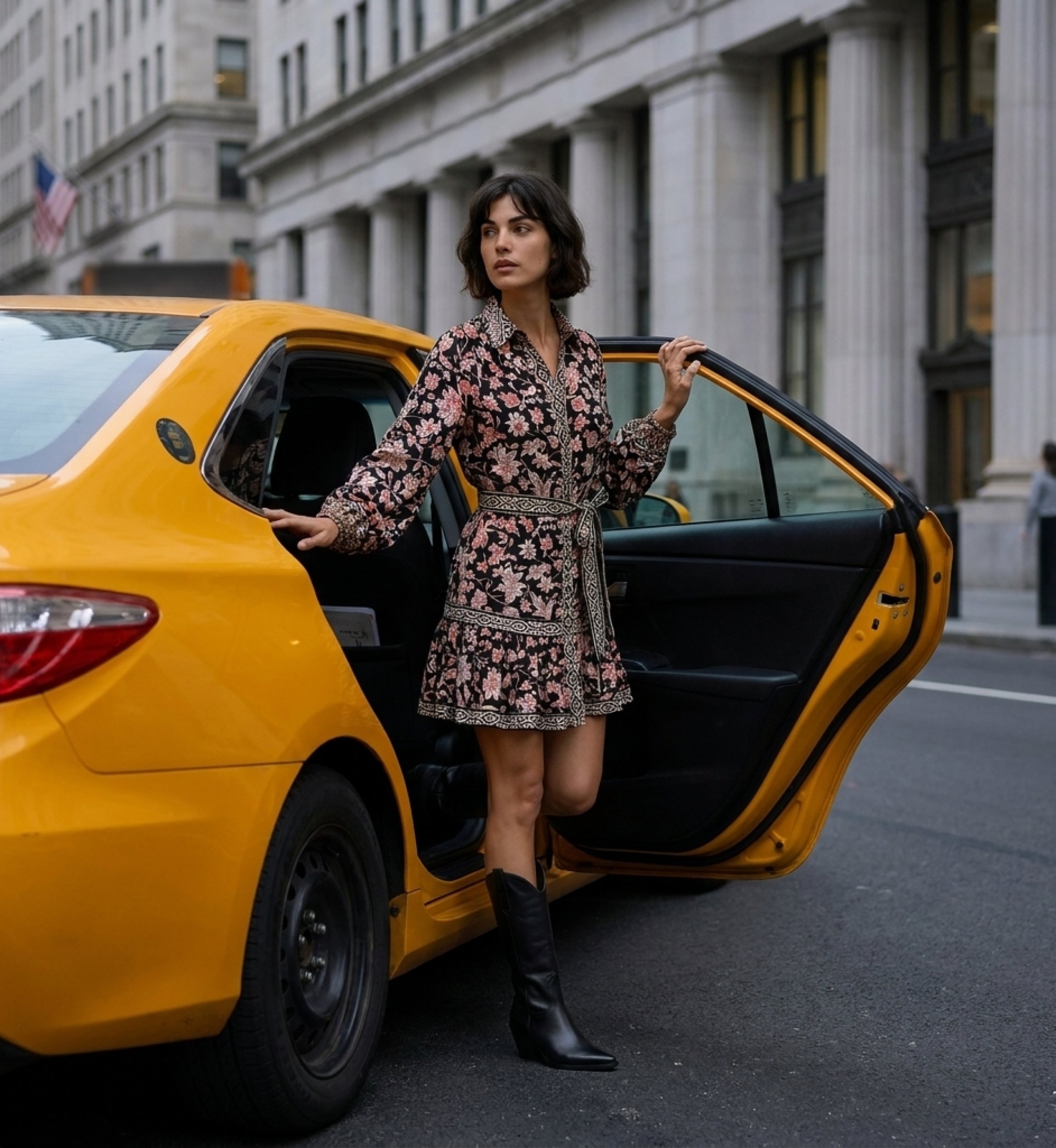 Black long-sleeve floral mini dress with collar, tied belt, tiered ruffled skirt, captured in a dynamic city scene.