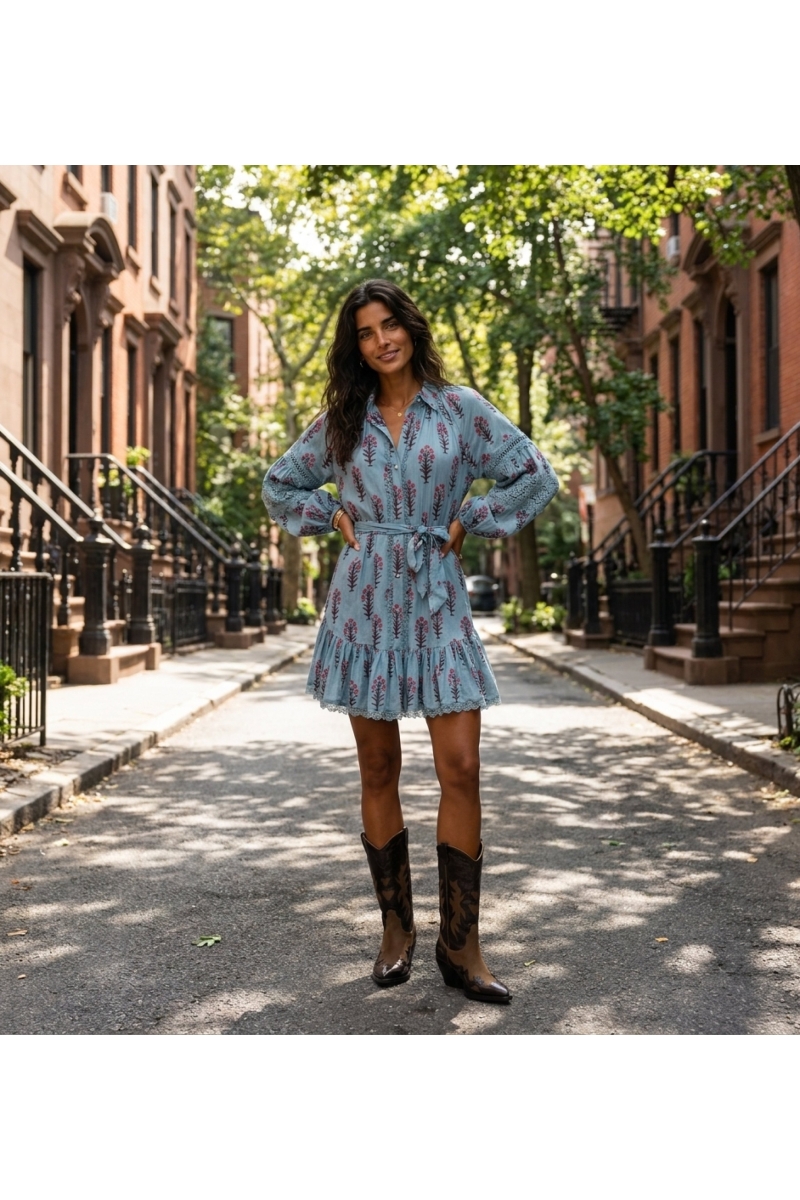 Mini vestido azul claro com estampa floral, mangas balão longas com renda, botões e cintura amarrada.