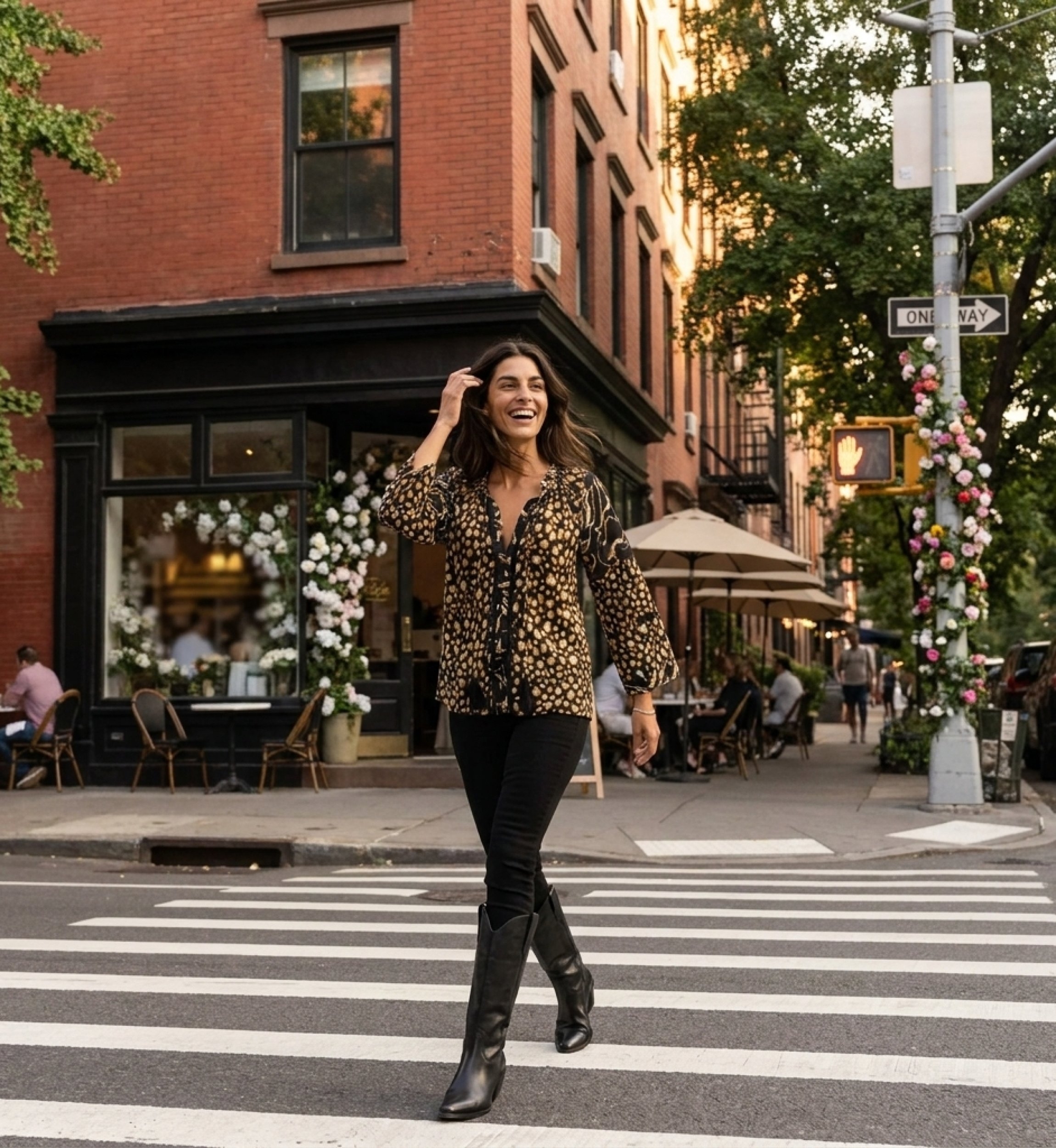 Loose black blouse with gold white leopard print, ruffled neckline, black pom-pom and tassel trim, styled outdoors.