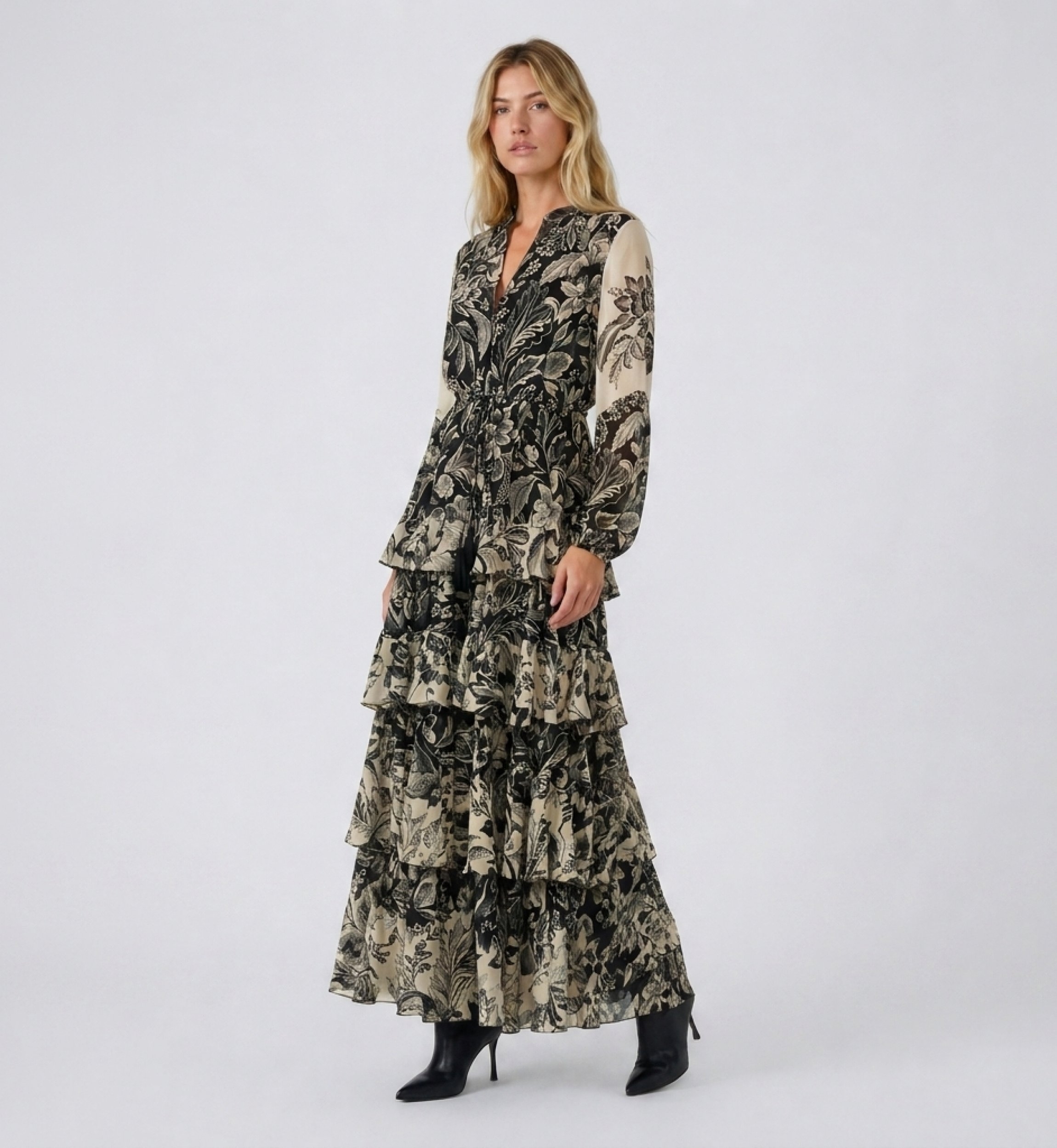 Front view of a long black and beige floral maxi dress with V-neck, long sleeves, elasticated waist, and tiered ruffled skirt in