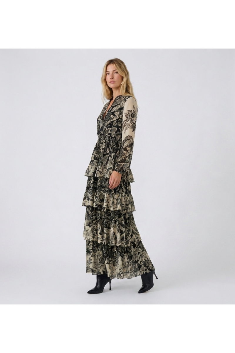 Three-quarter view of a black and beige floral print maxi dress with V-neck, long sleeves, elasticated waist, and tiered ruffled