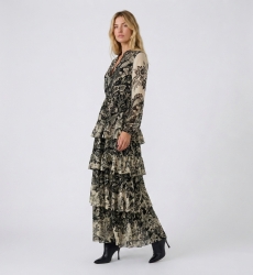 Three-quarter view of a black and beige floral print maxi dress with V-neck, long sleeves, elasticated waist, and tiered ruffled