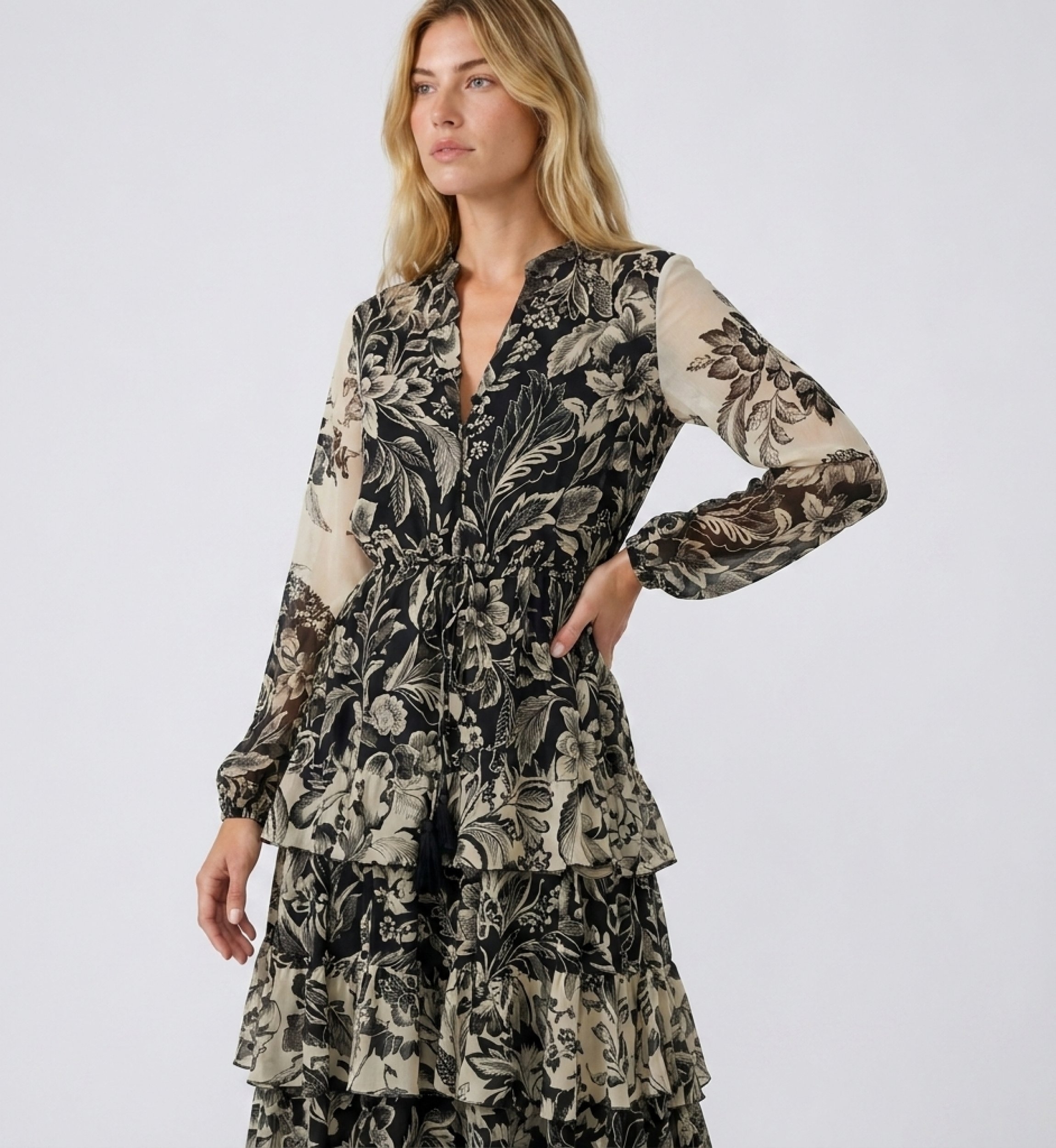 Vestido maxi preto bege floral, decote V, mangas compridas, cintura elástica, saia folhos, tecido leve, vista 3/4.