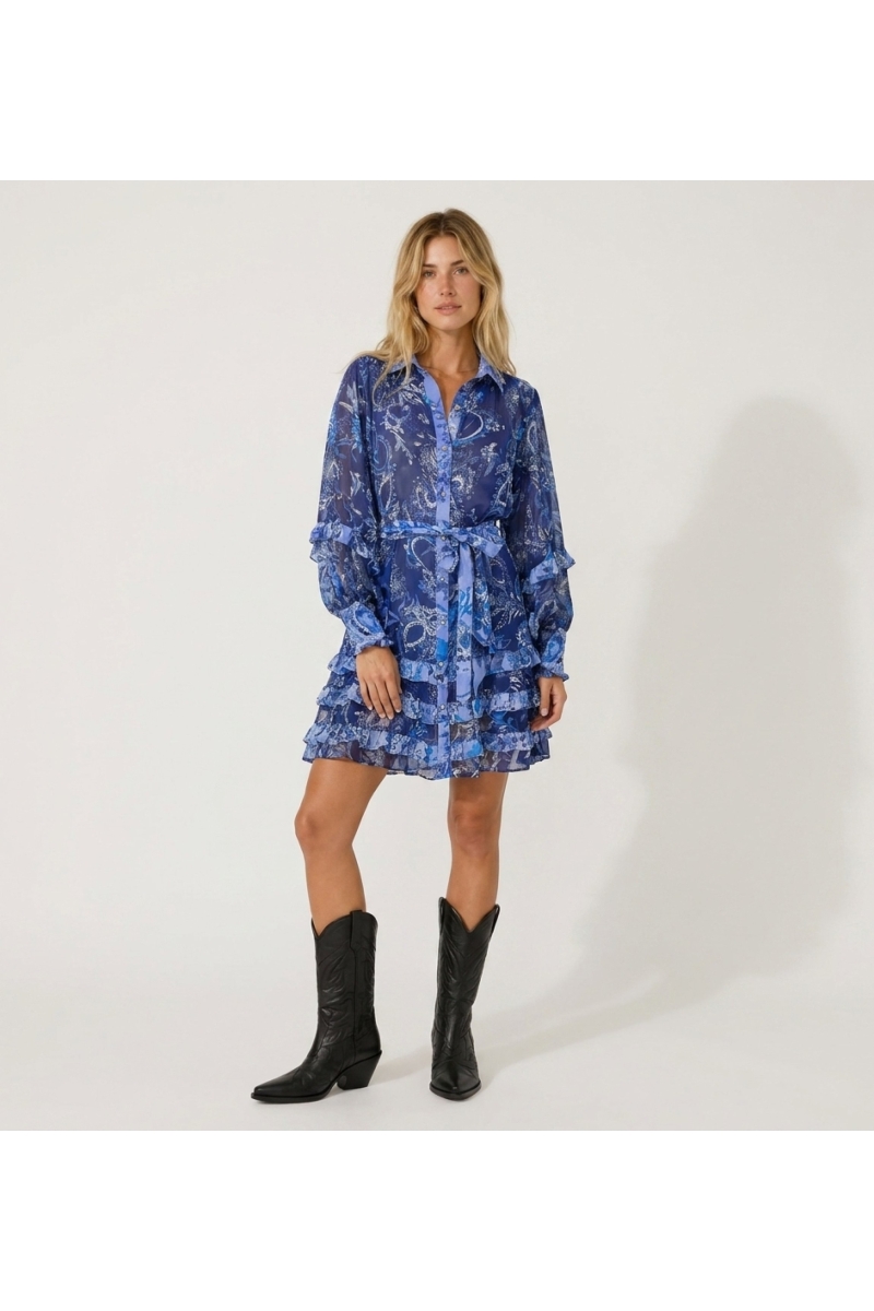 Vestido corto transparente azul y blanco con estampado floral, mangas largas con volantes y falda escalonada.