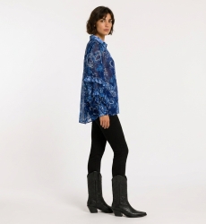 Three-quarter view of a blue sheer long-sleeve blouse with paisley floral print, ruffled cuffs, and a collared V-neck.