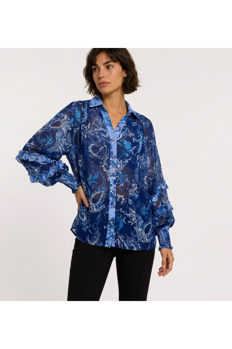 Three-quarter view of a sheer blue long-sleeve blouse with paisley floral pattern, ruffled cuffs, and collared V-neck.