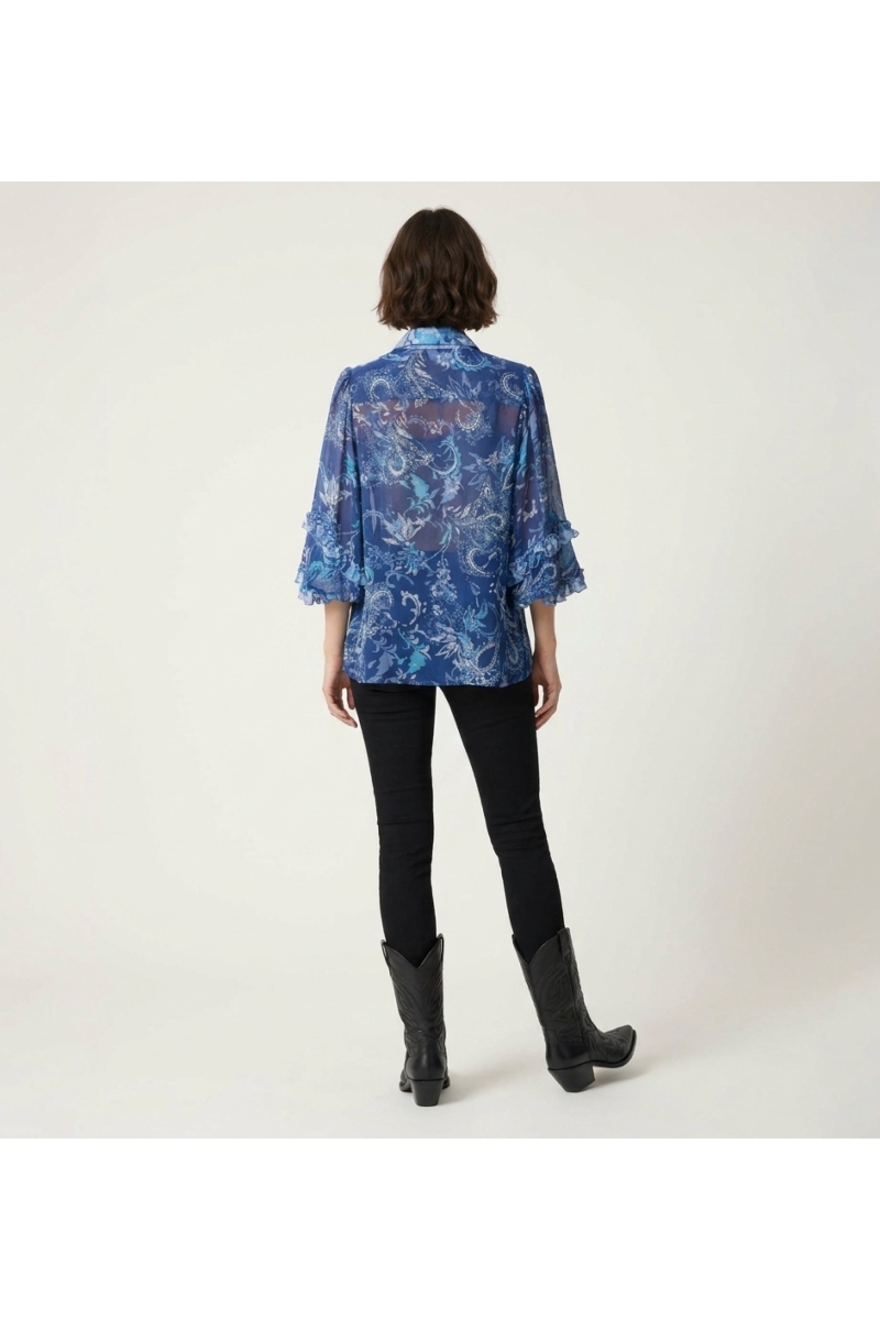 Vista trasera: blusa transparente azul de manga larga, estampado cachemira floral, puños con volantes, cuello V. Top elegante.