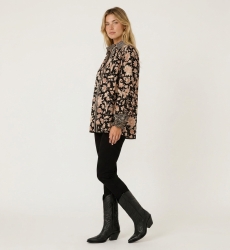 Blusa negra manga larga, estampado floral crema y óxido, cuello, puños con volantes, tejido ligero.