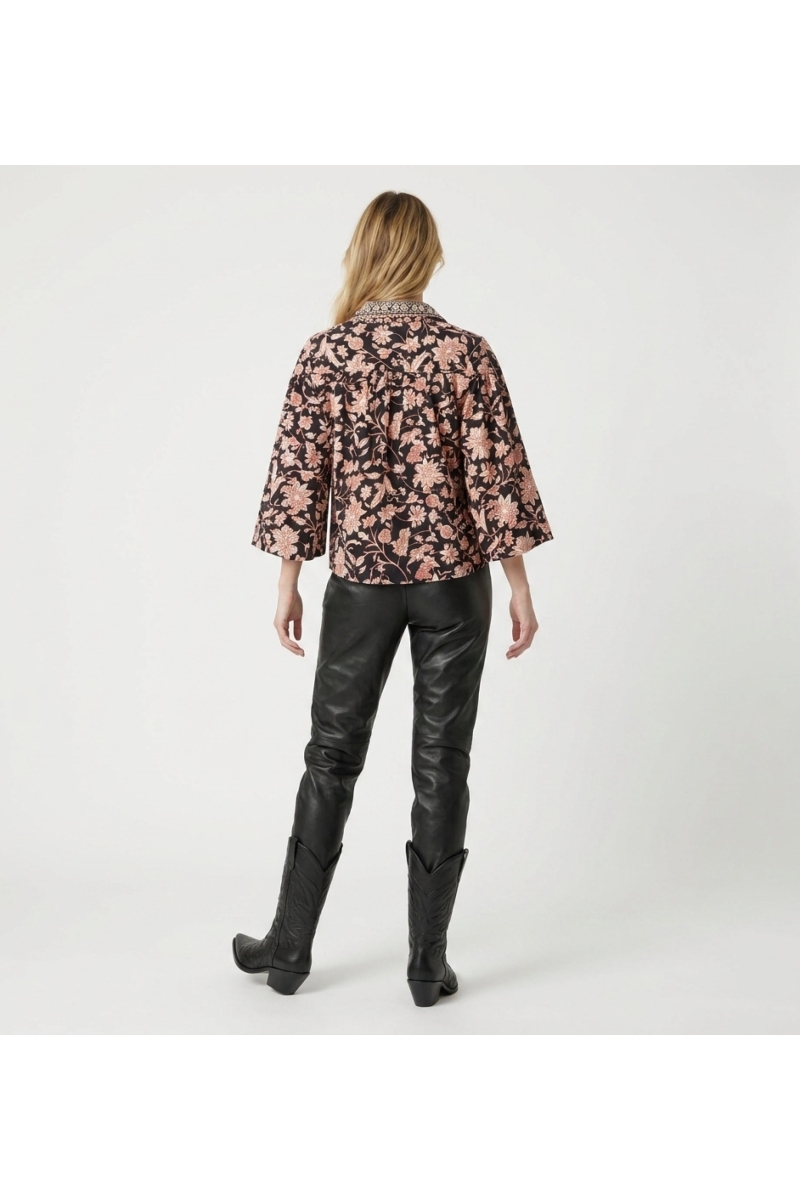 Black long-sleeve floral blouse, cream and rust pattern, collared, ruffled cuffs, lightweight fabric, back view.
