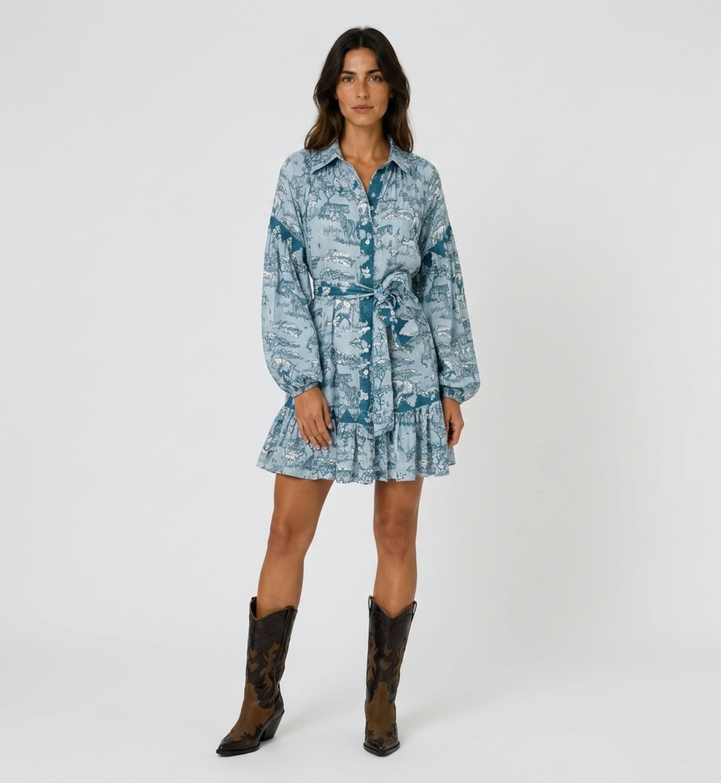 Light blue and teal safari toile shirtdress with long balloon sleeves, collared neck, tie waist, ruffled hem, front view.