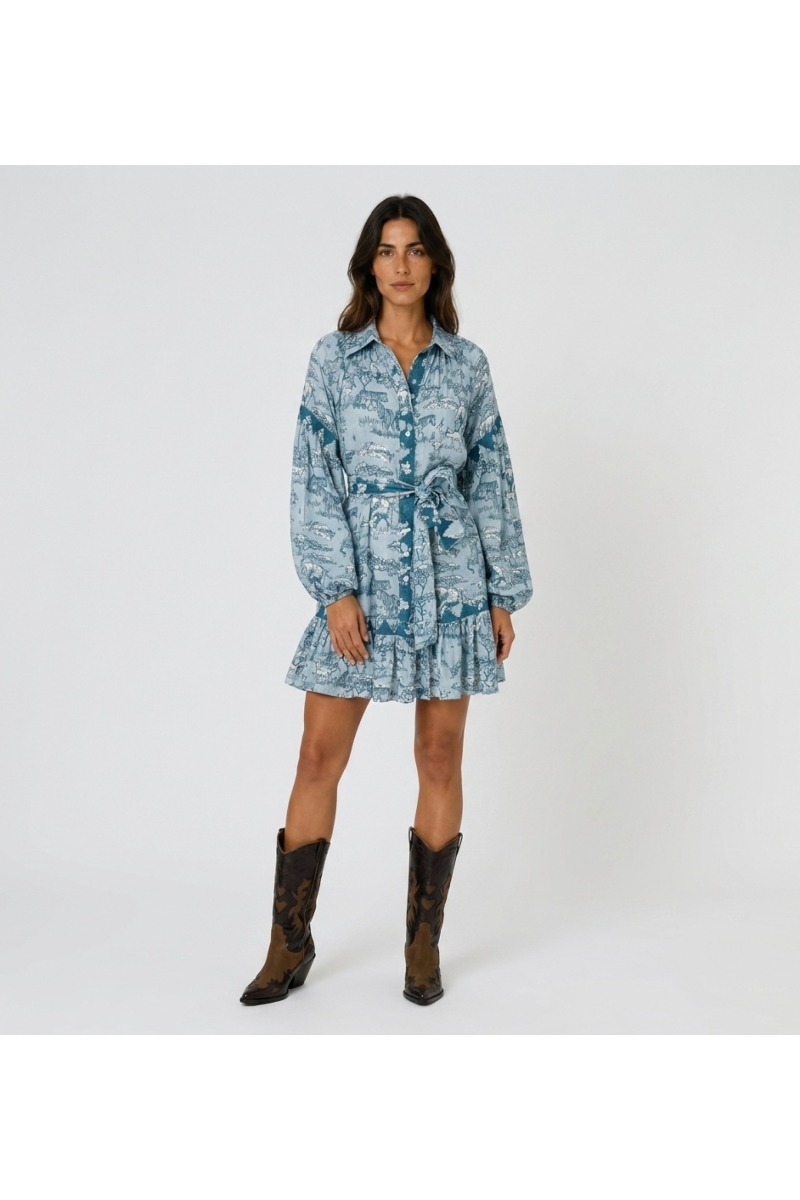 Light blue and teal safari toile shirtdress with long balloon sleeves, collared neck, tie waist, ruffled hem, front view.