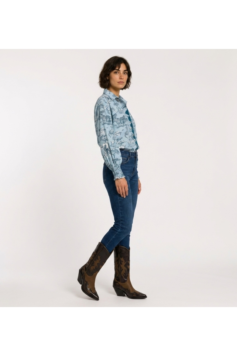 Light blue safari animal print button-up shirt, long puffed sleeves with shirred cuffs, three-quarter view.