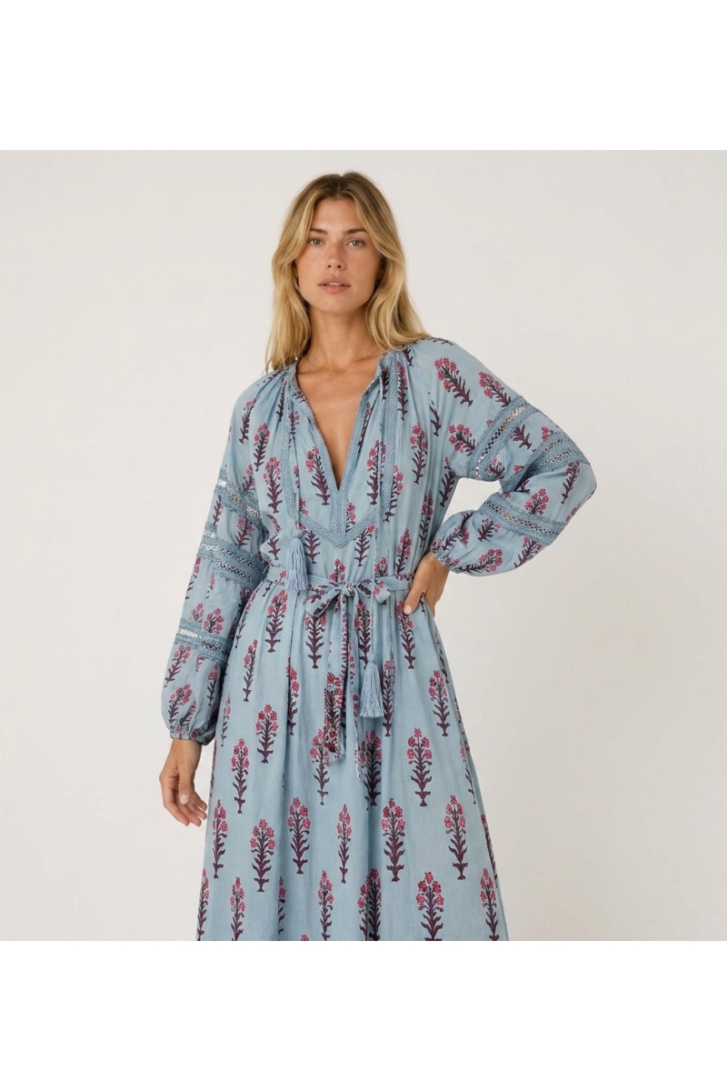 Light blue floral midi dress, three-quarter view. Features long balloon sleeves, V-neck, and tie-waist with tassels.