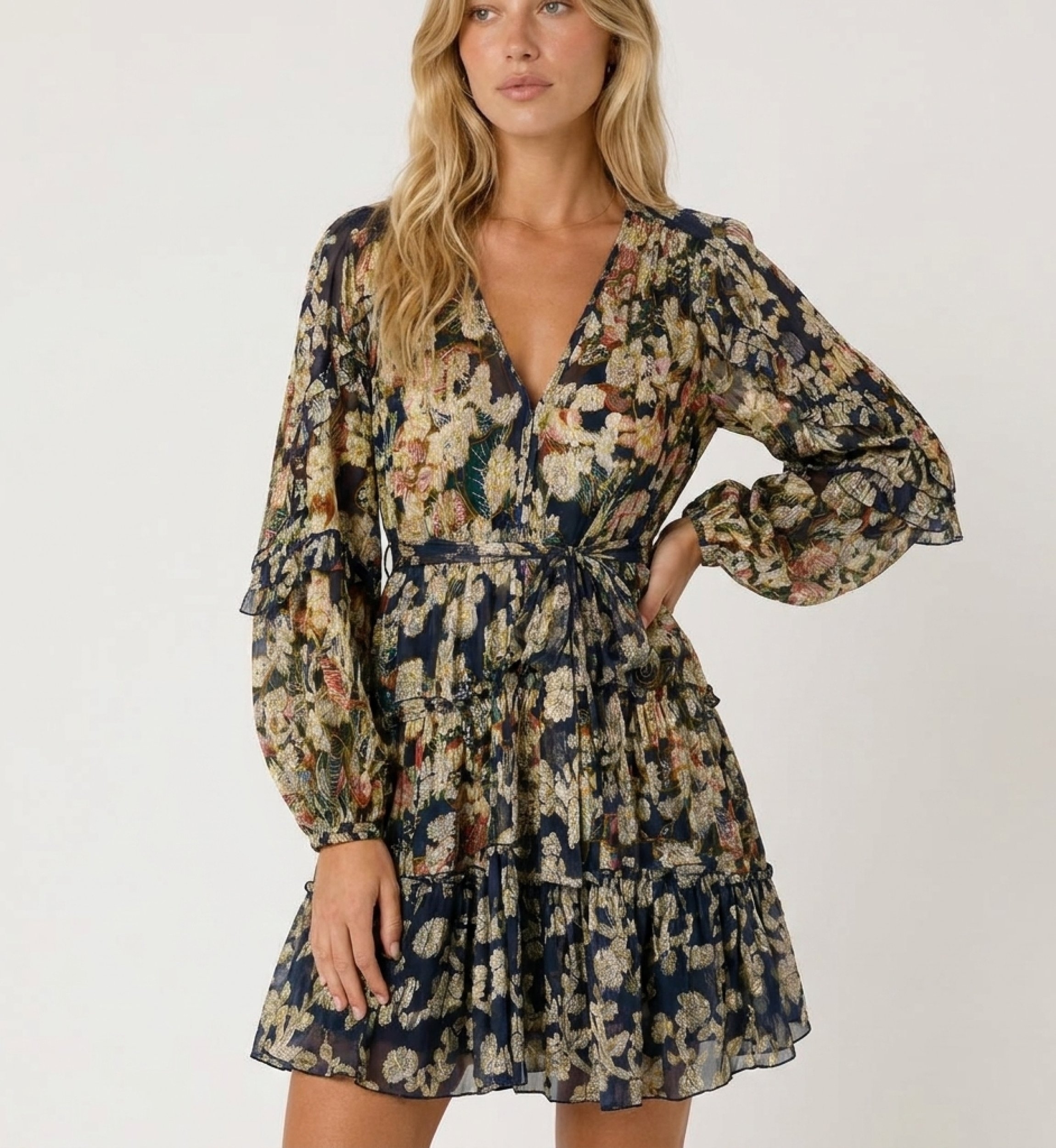 Navy blue short-sleeved V-neck dress with gold floral pattern, tiered skirt, tie waist, sheer fabric, three-quarter view.