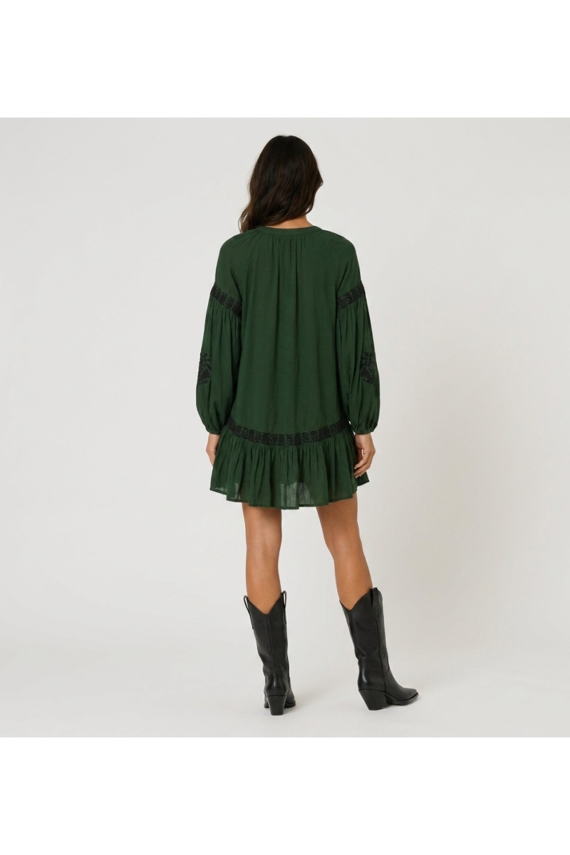 Mini vestido verde oscuro con cuello, bordado floral negro, cintura anudada, mangas largas voluminosas, vista trasera.