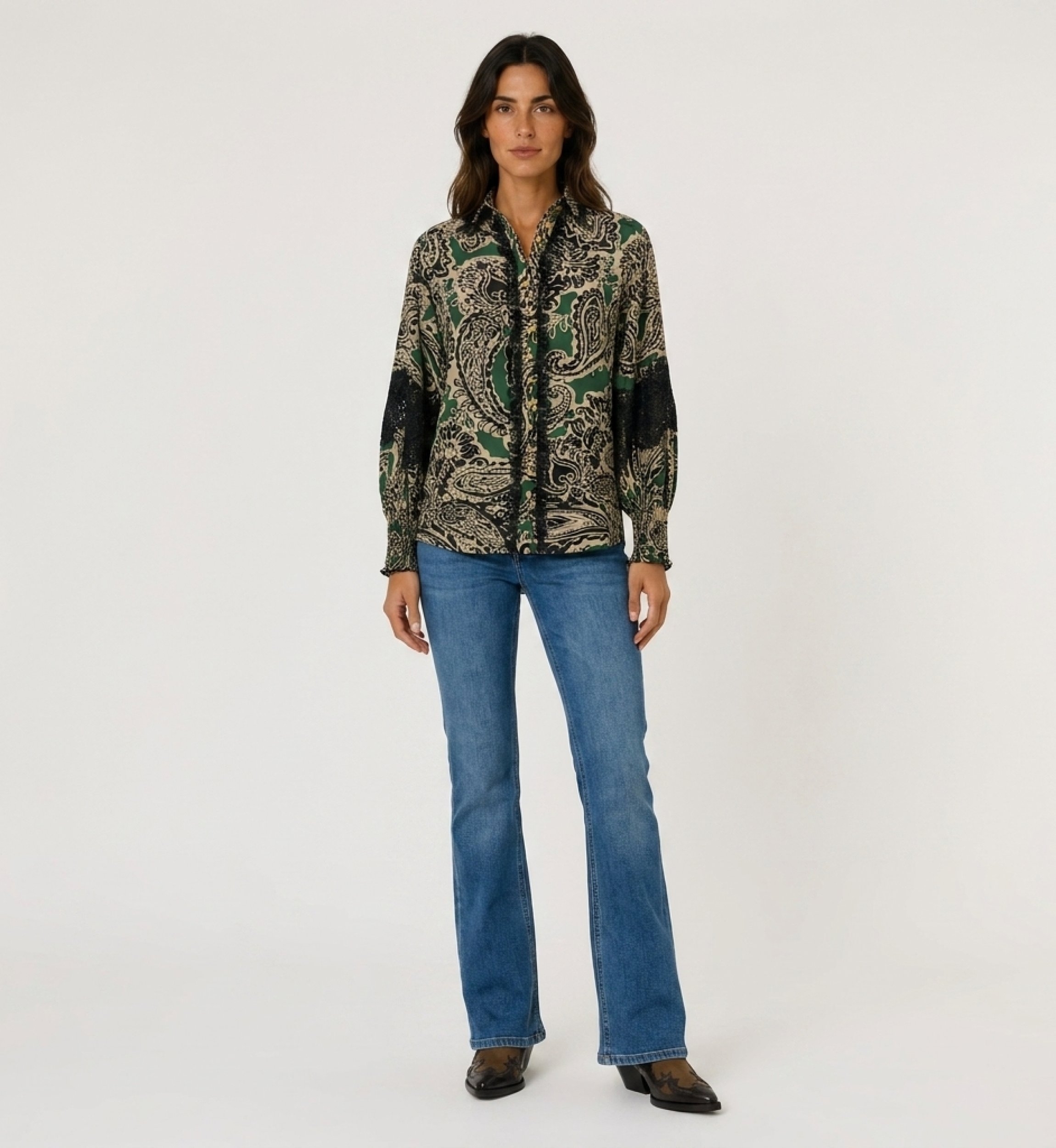 Front view of a women's long-sleeve collared shirt with green, black, beige paisley pattern, black lace, gold buttons, smocked c