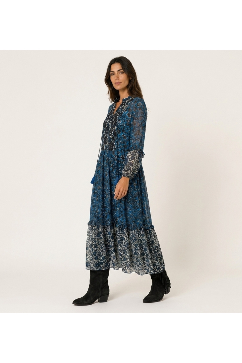 Vestido longo em camadas de manga comprida com estampado floral azul, preto e branco, corte solto e tecido leve.