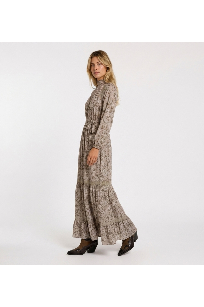 Light pink floral maxi dress with green gold leaf pattern, high smocked neck, long puff sleeves, and lace trim details.