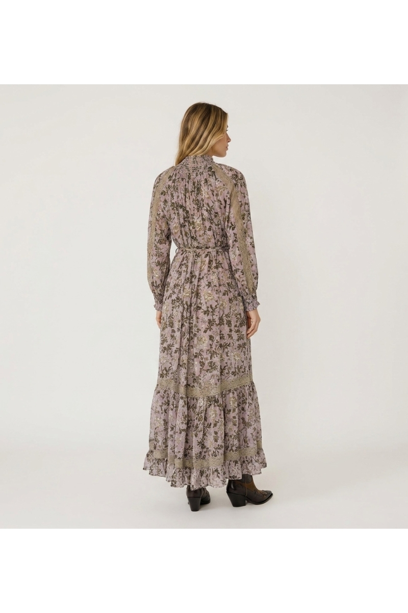 Back view of a light pink floral maxi dress with green/gold leaf print, high smocked neck, puff sleeves, and lace.