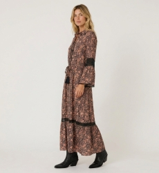 Three-quarter view of a black and peach paisley print long-sleeve maxi dress with collared neckline, smocked waist, and lace tri
