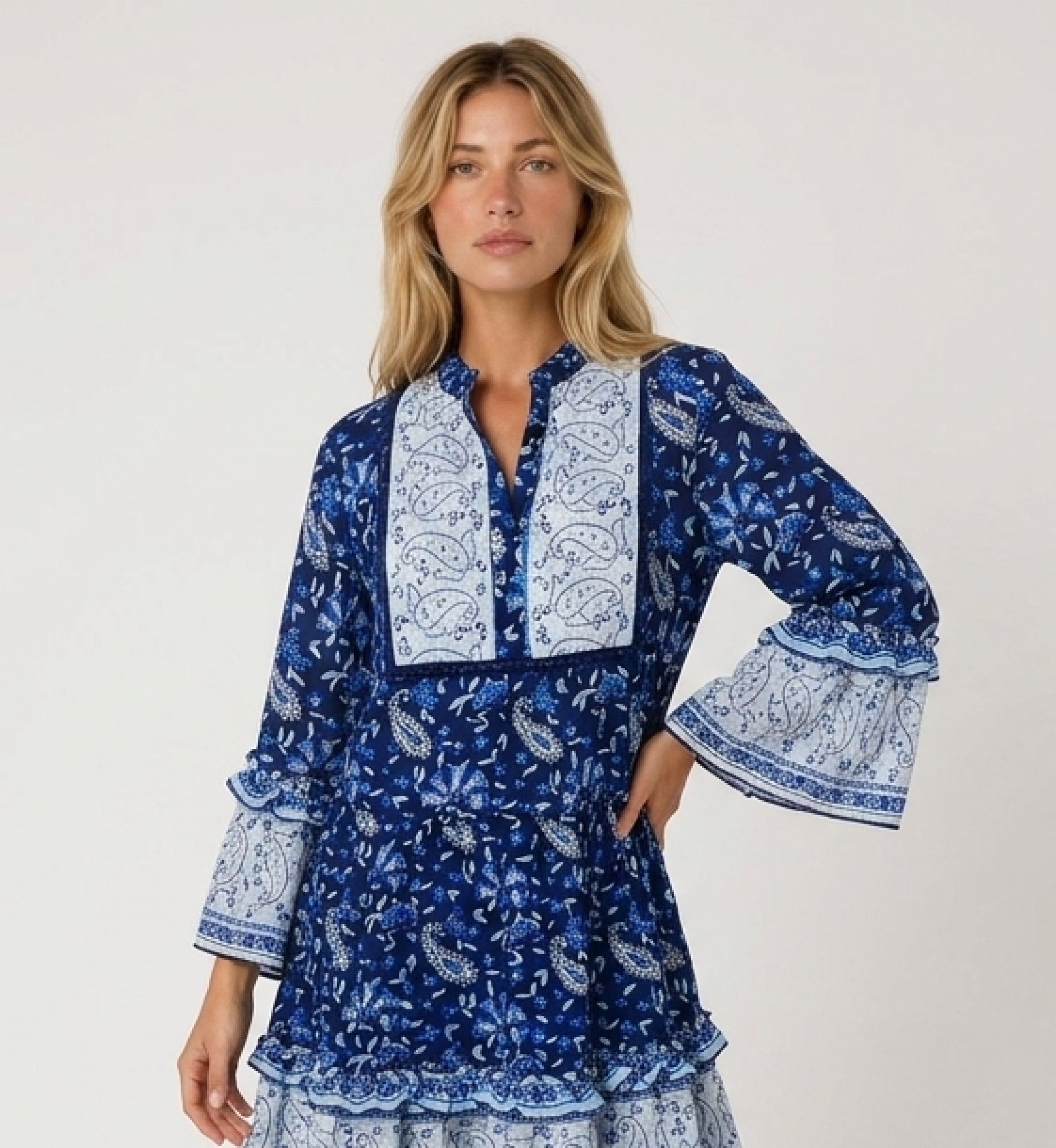 Minivestido azul e branco estampado paisley floral, decote V, mangas três quartos com babados, saia em camadas, vista lateral.