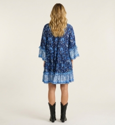 Costas de mini vestido azul e branco com padrão paisley floral, decote V com gola, mangas três quartos com folhos e saia em cama