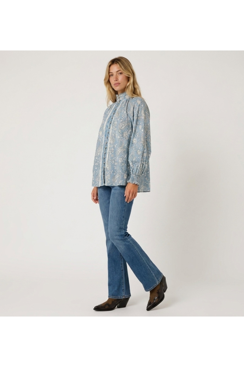 Blusa feminina azul clara manga longa, padrão paisley, gola alta, abotoada, punhos com babados.