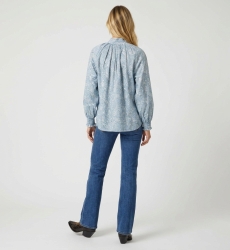 Blusa azul claro de manga comprida com estampa paisley branca, gola alta, punhos com babados, vista costas. Camisa elegante.