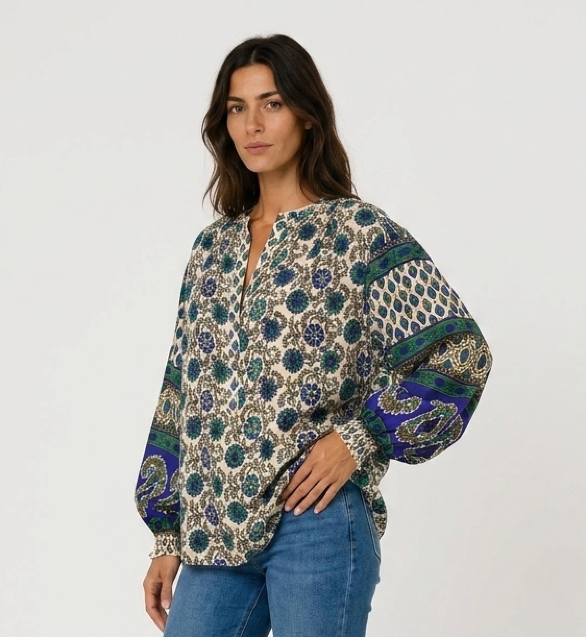 Cream long-sleeve blouse with blue green floral print. Lightweight fabric, contrasting balloon sleeves. Three-quarter view.