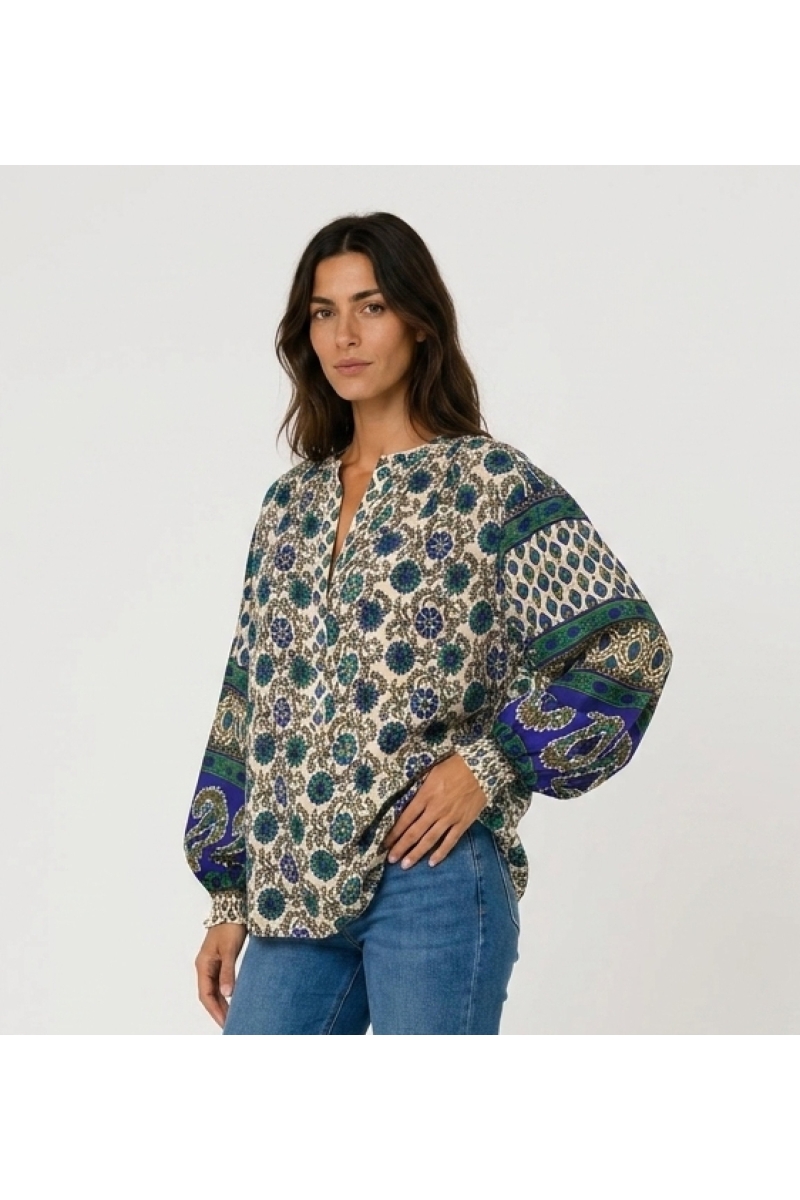 Cream long-sleeve blouse with blue green floral print. Lightweight fabric, contrasting balloon sleeves. Three-quarter view.