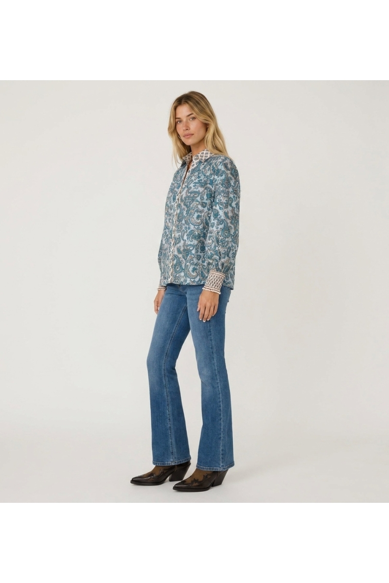 Blusa femenina blanca elegante de corte suelto en tejido ligero y fluido, vista de tres cuartos. Perfecta para un look casual ch