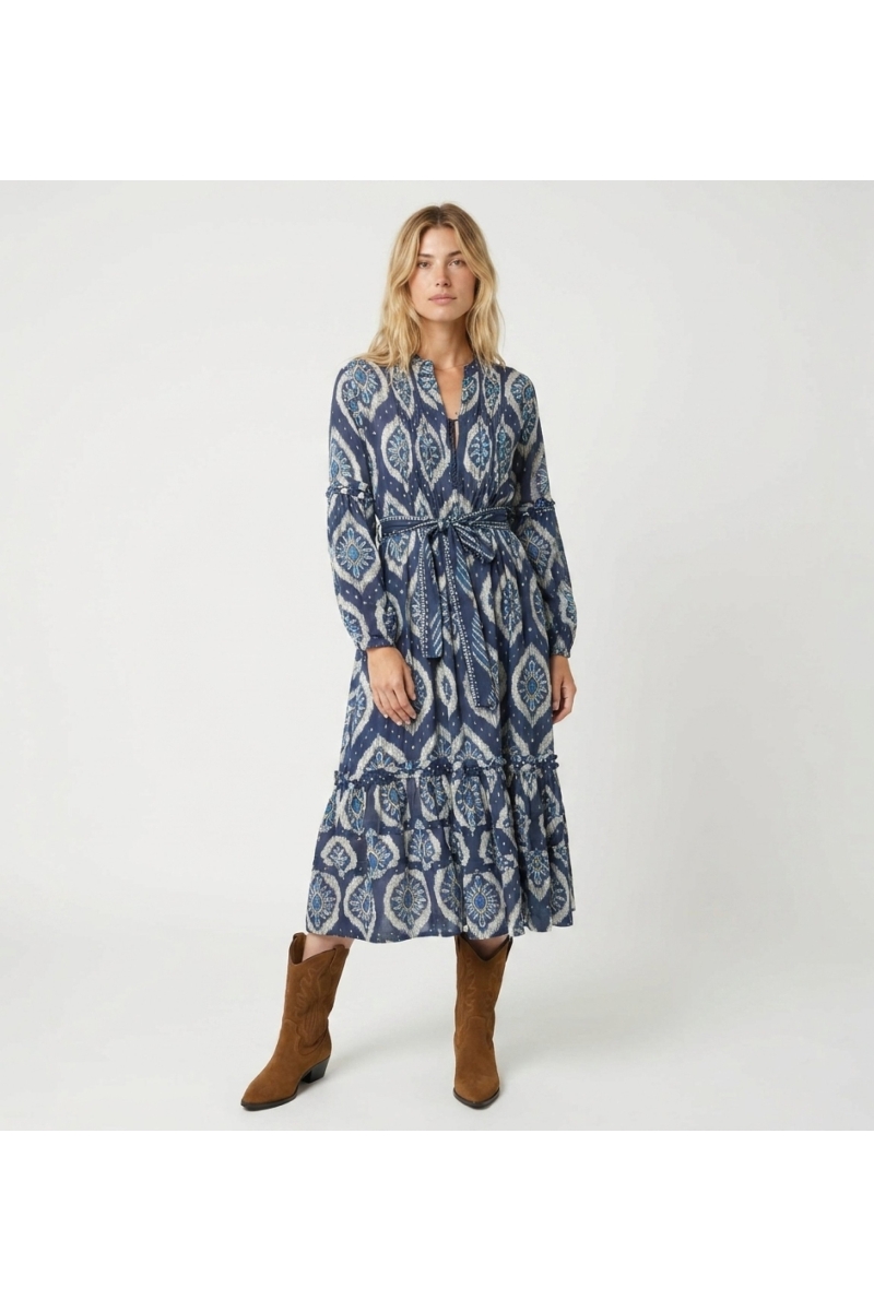 Front view of a blue and white ikat pattern midi dress with long puff sleeves, tiered skirt, and tie belt.