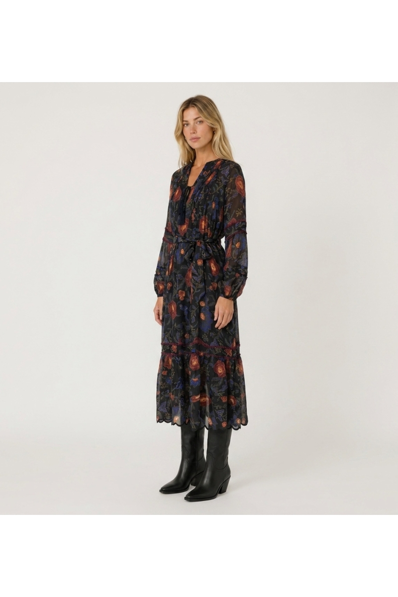 Vestido midi negro manga larga, estampado floral rojo y azul, falda escalonada, cintura anudada, tejido ligero semitransparente.