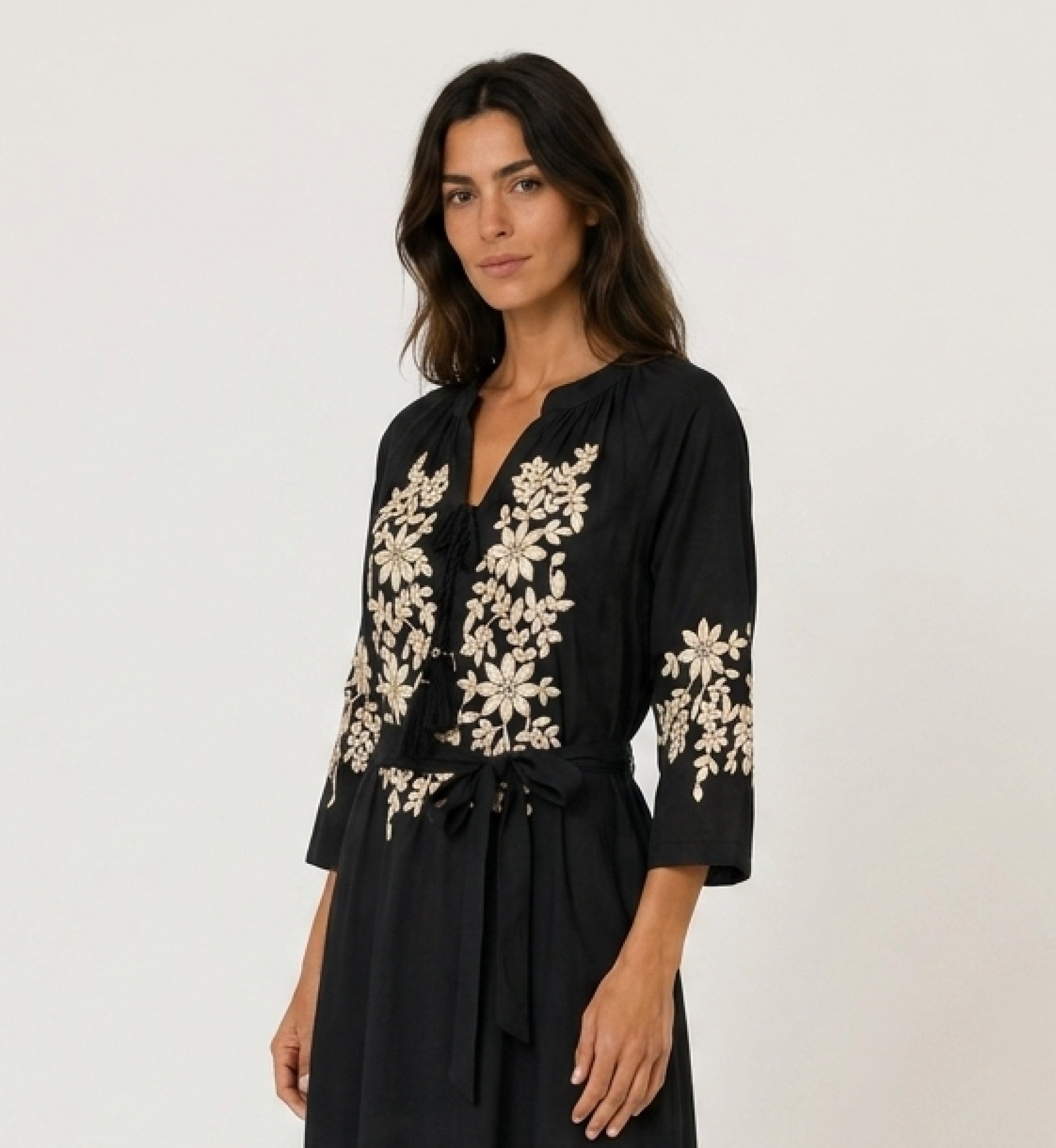 Black midi peasant dress, loose fit, with gold floral embroidery on bodice, sleeves, hem, and tie-waist, three-quarter view.