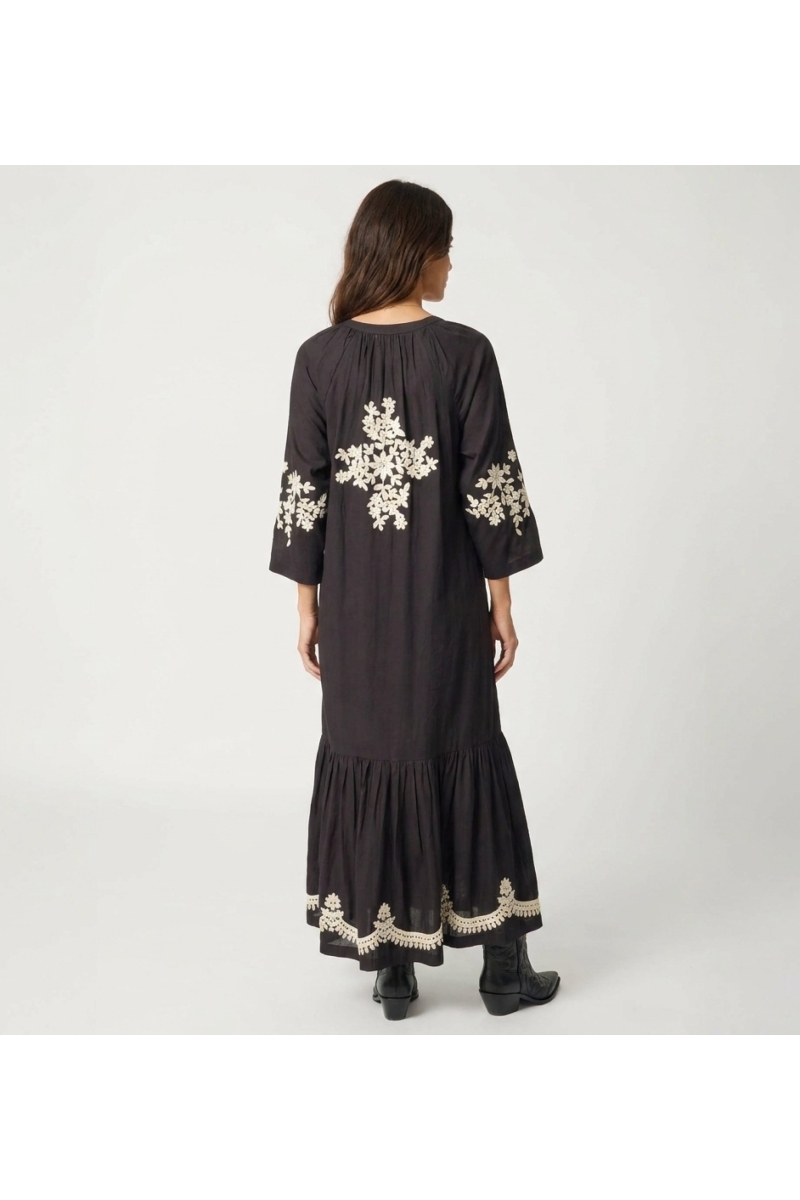 Vestido midi campesino negro, silueta holgada con bordado floral dorado en espalda, mangas y bajo. Vista trasera.