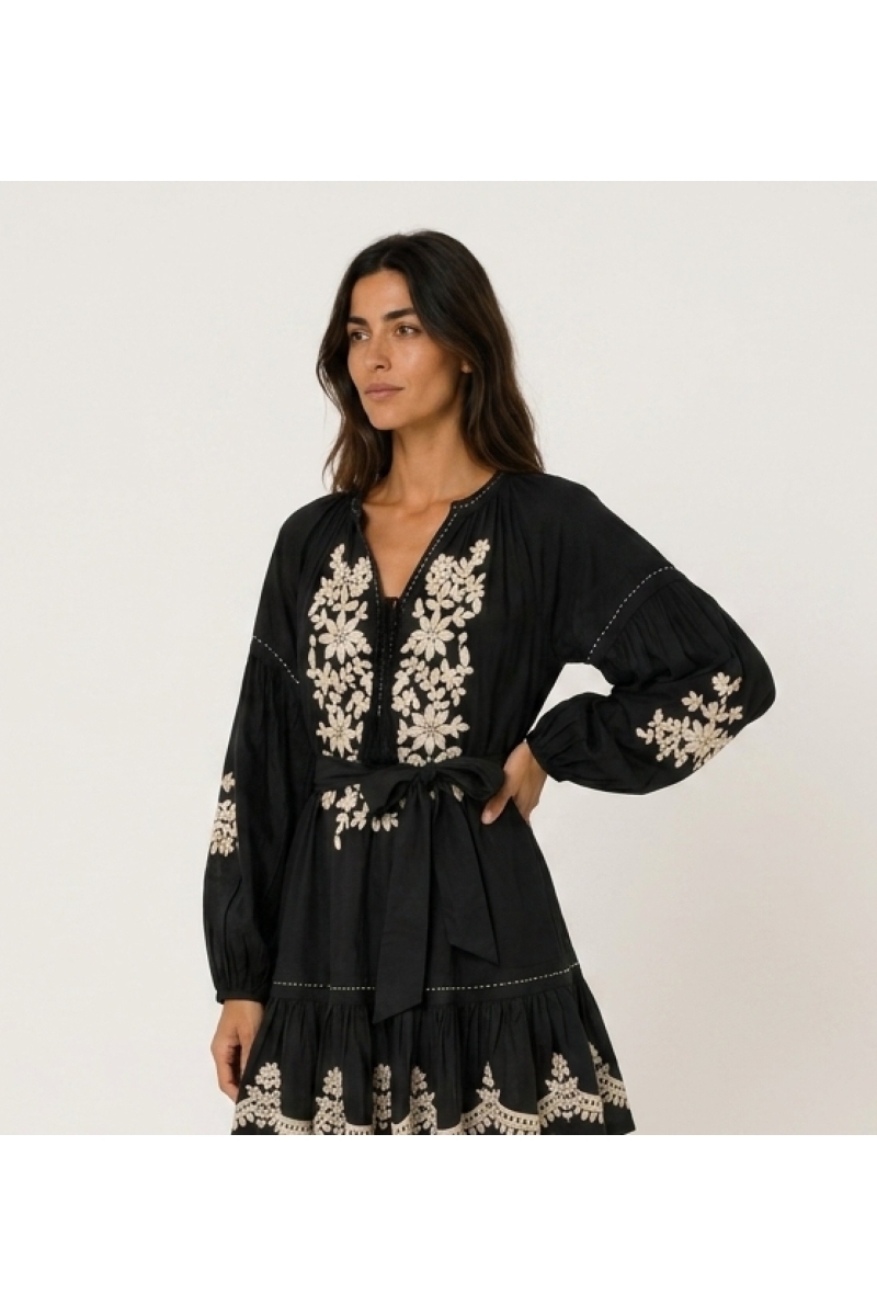 Vestido mini preto solto com mangas balão longas, saia em camadas, bordado floral branco e cintura com laço.