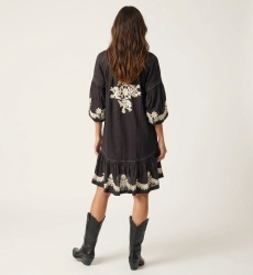 Black mini dress, loose fit, long balloon sleeves, tiered skirt, white floral embroidery, tie-waist, back view.