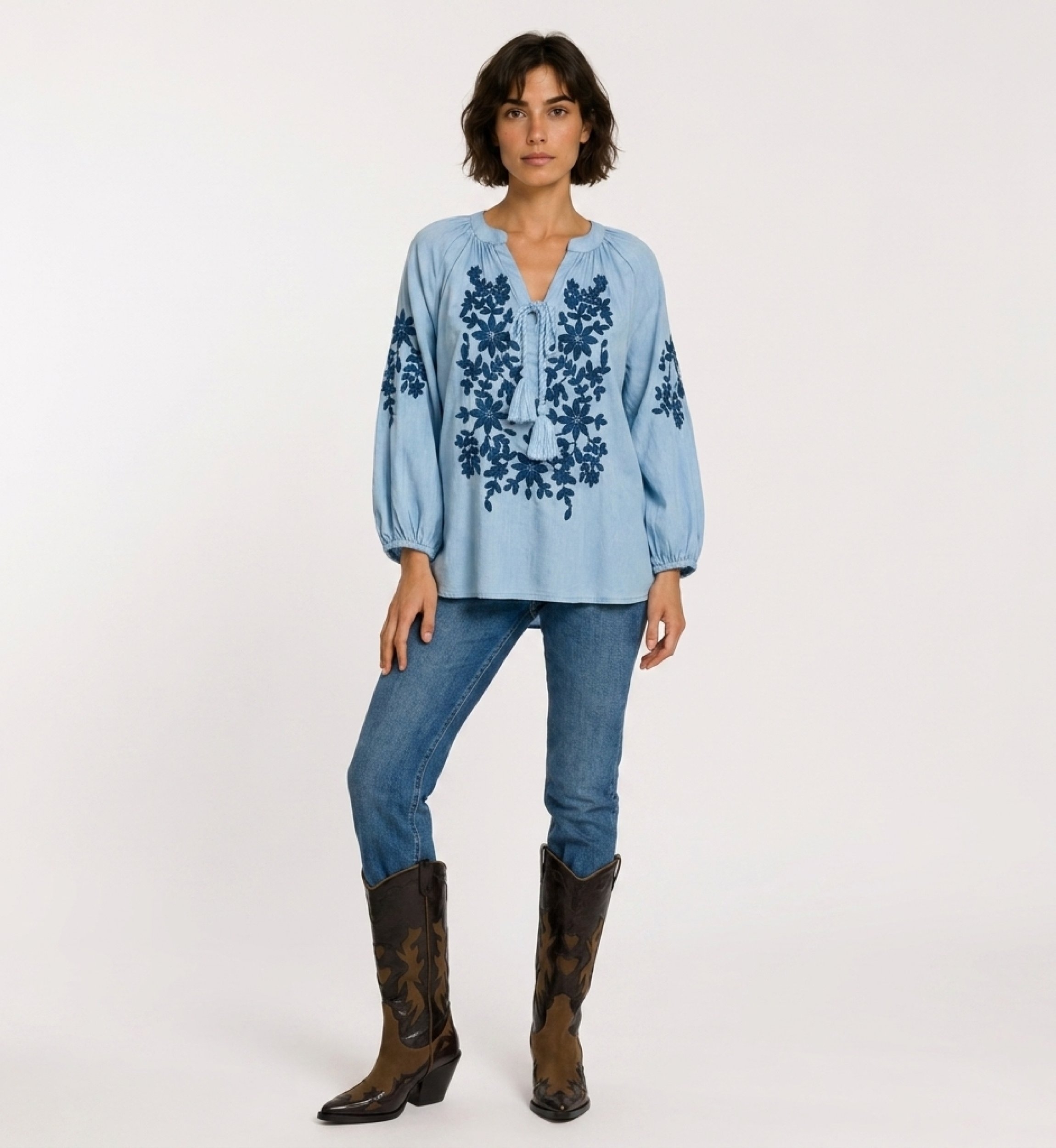 Front view of a black long-sleeve peasant blouse with v-neck, tie closure, and cream floral embroidery. Linen-look fabric.