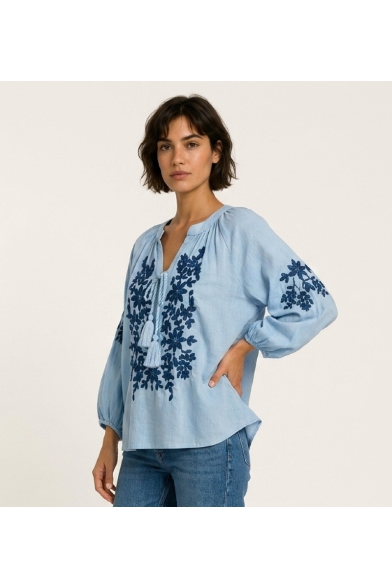 Black long-sleeve peasant blouse with v-neck, tie closure, and cream floral embroidery. Linen-like fabric, three-quarter view.