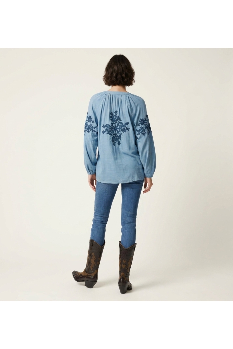 Blusa campesina negra, manga larga, efecto lino, bordado floral crema. Vista trasera de blusa con cuello V y lazo.
