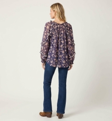 Espalda blusa fluida azul marino transparente, estampado floral blanco y melocotón, mangas largas con volantes.