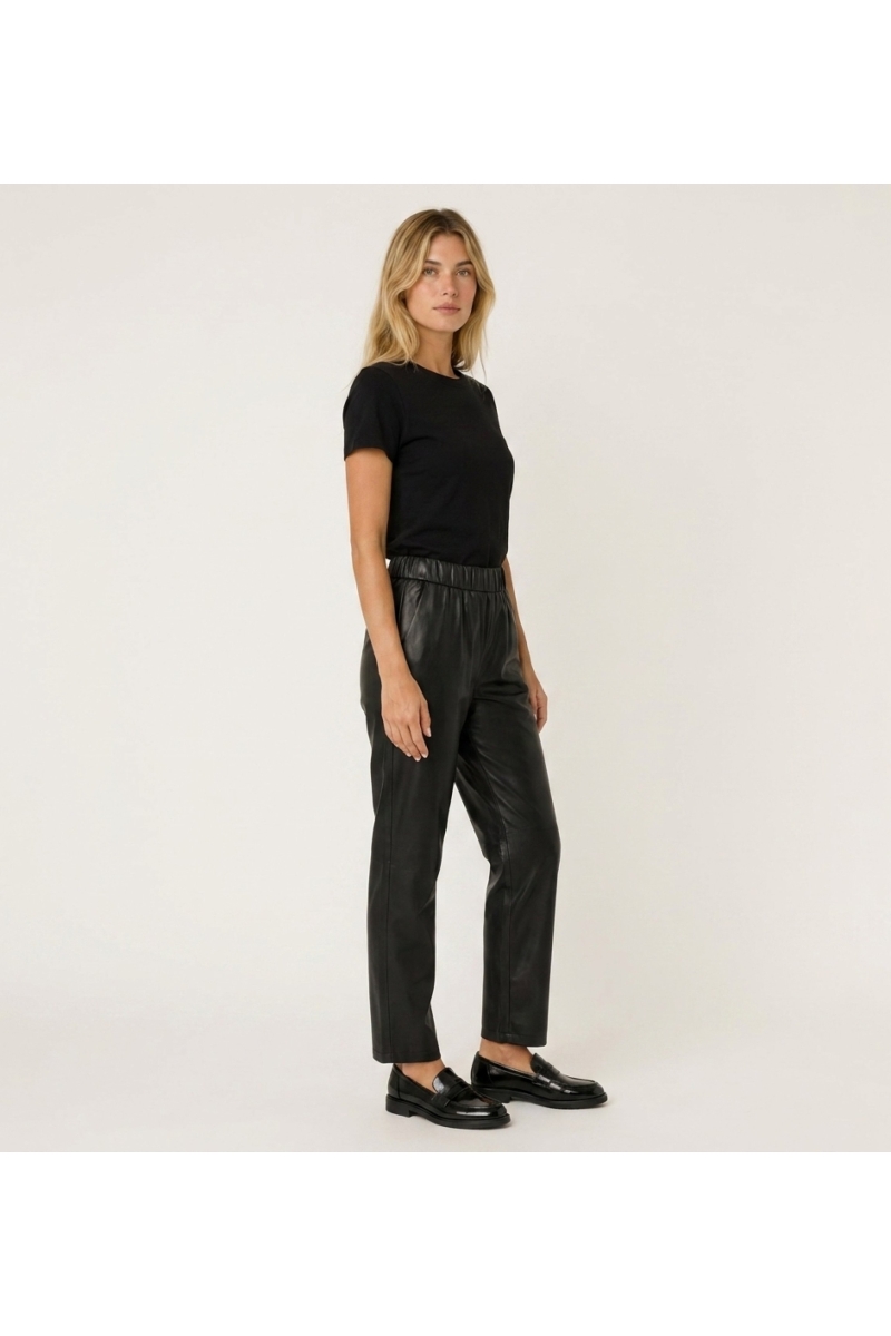 Pantalones de cuero para mujer, mostrados en vista de tres cuartos lateral. Diseño moderno y elegante.