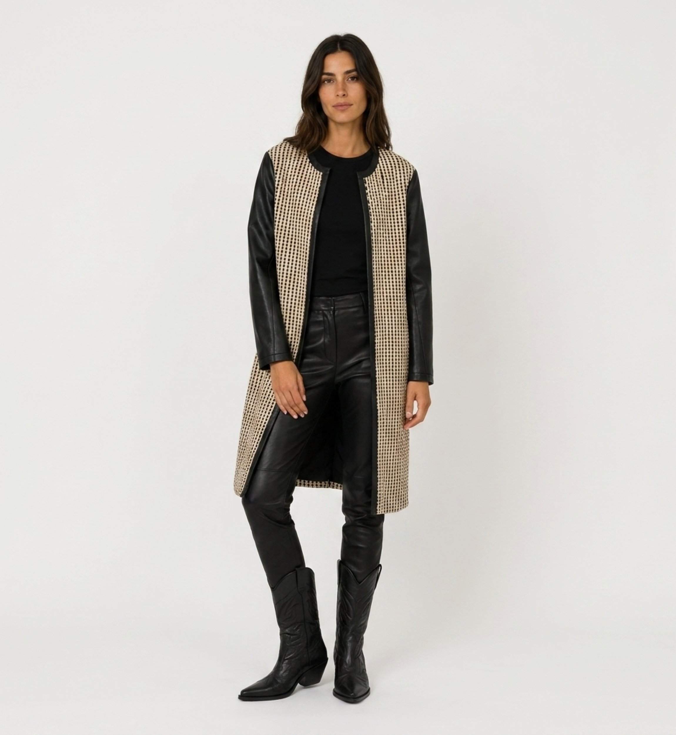 Front view of a collarless, open-front long jacket in black and beige woven fabric with faux leather sleeves.