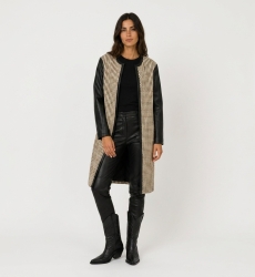 Front view of a collarless, open-front long jacket in black and beige woven fabric with faux leather sleeves.