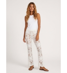 Front view of white lace flared trousers with floral pattern, nude lining, and scalloped hem.